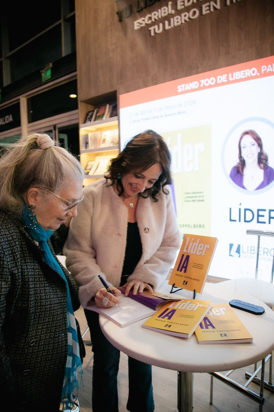 Ingrid firmando un ejemplar de Líder IA a una lectora en la Feria del Libro de Buenos Aires